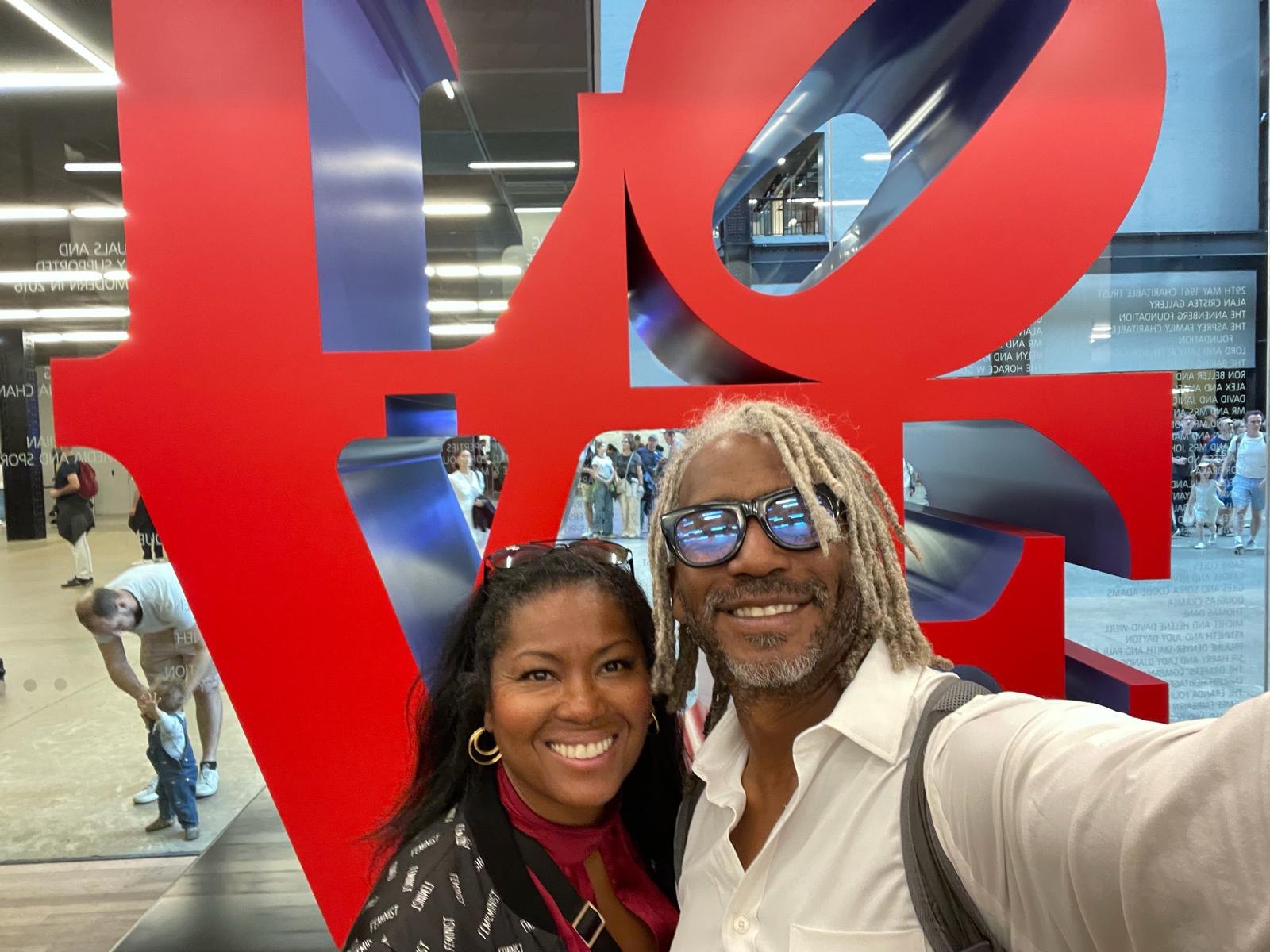 Kimberly G. Jackson in front of a red LOVE sculpture at a museum